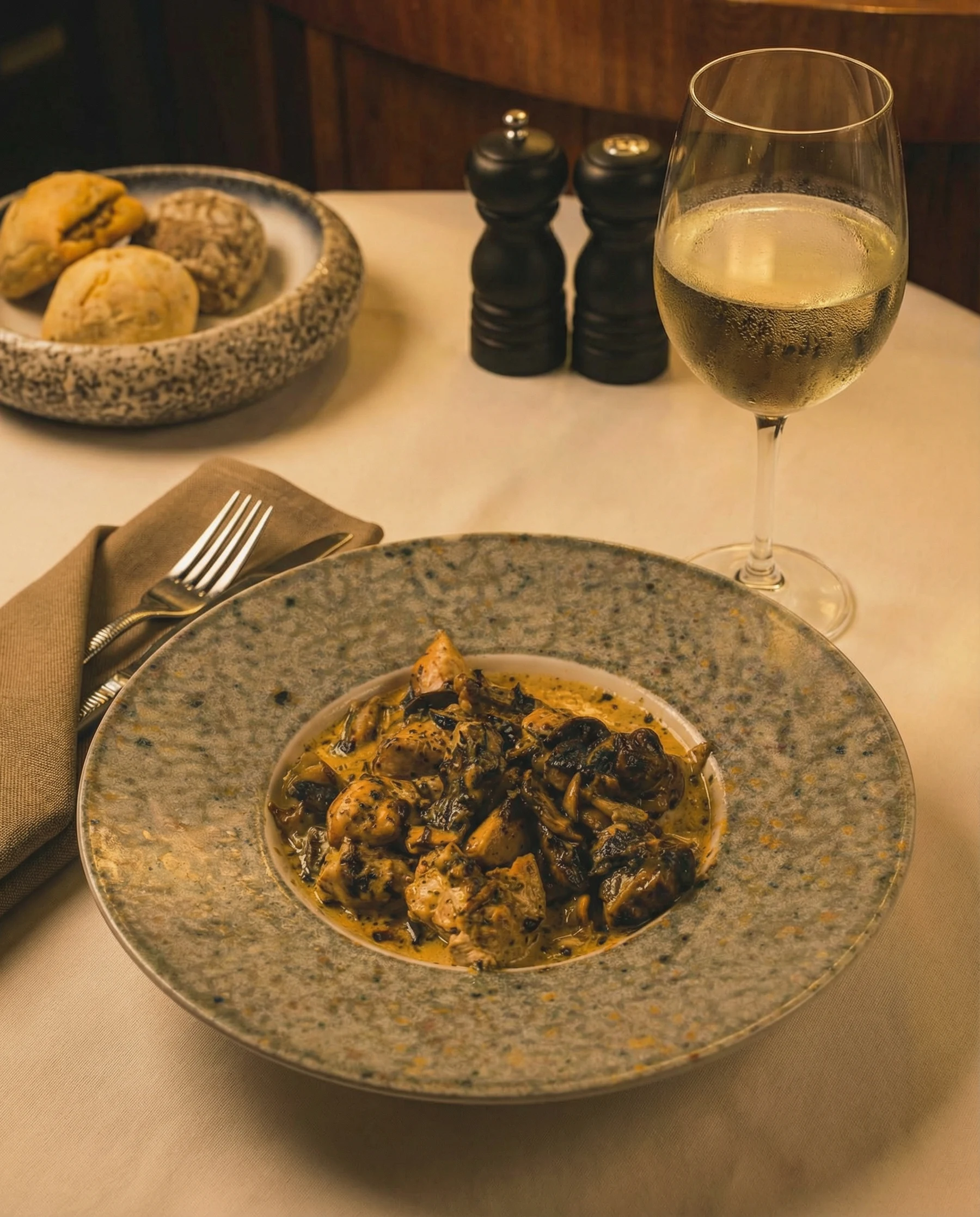 A dish and white wine at Pardon My French